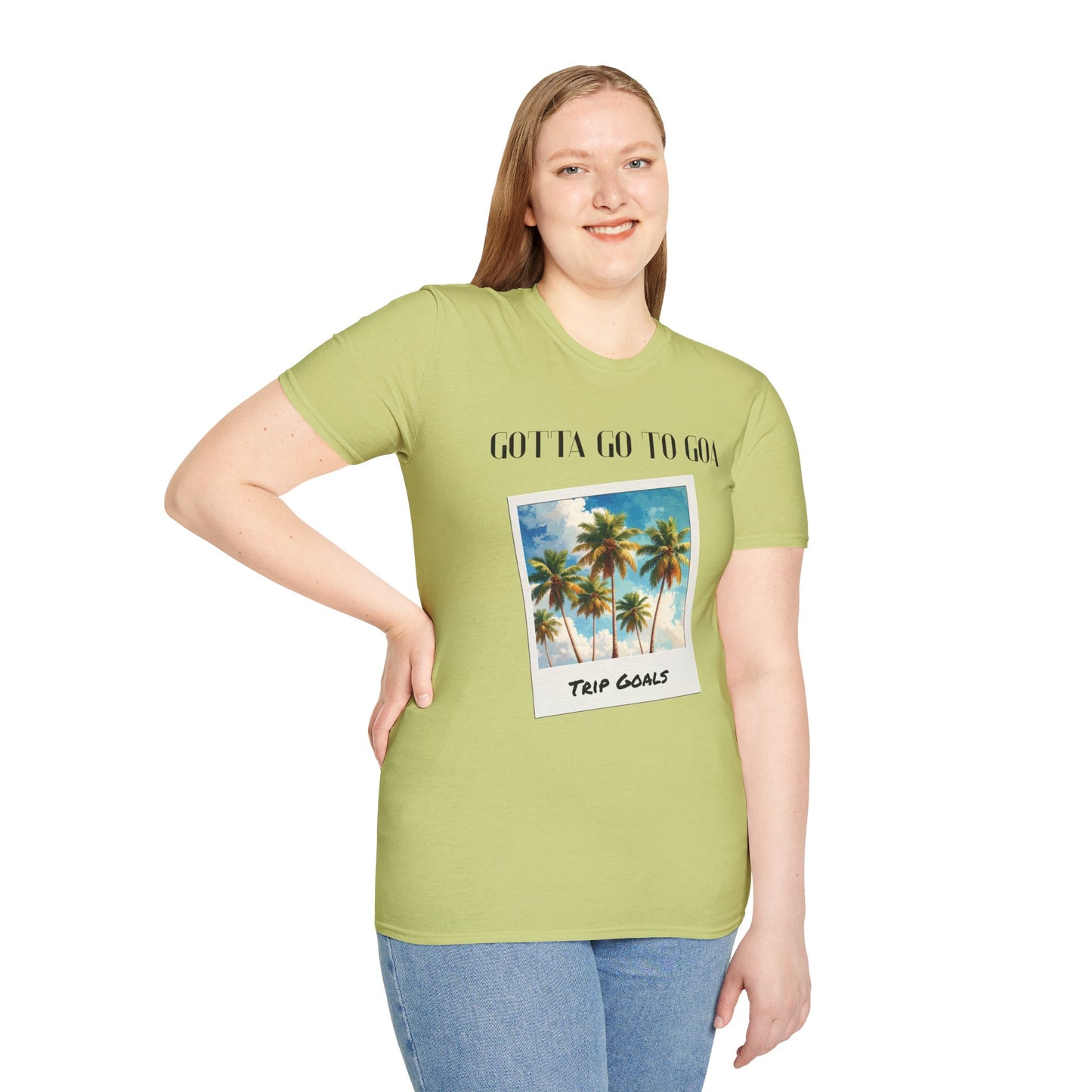 a woman wearing a pistachio shirt that says gotta go to goa with a graphic of goa beach as a postcard that says trip goals