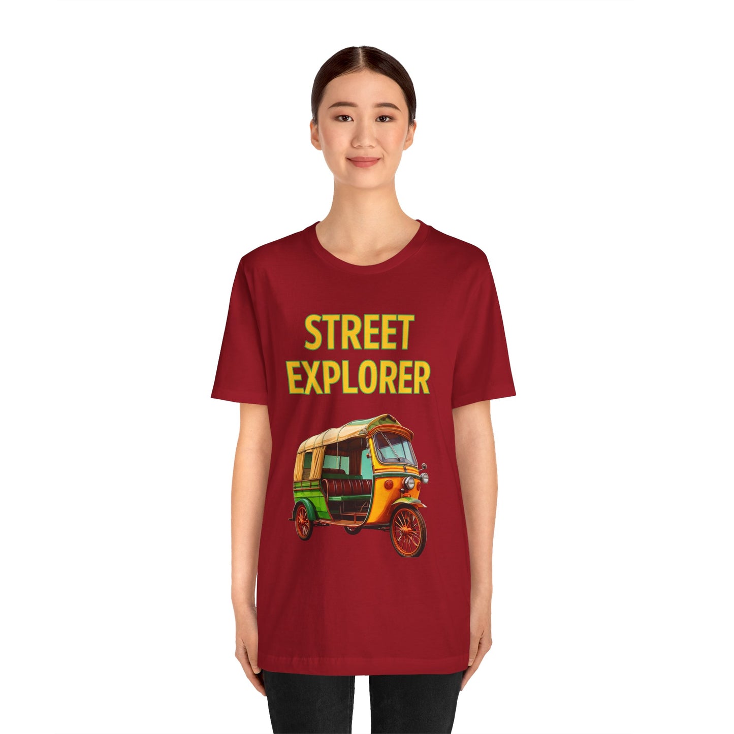 a woman wearing a canvas red shirt that says street explorer with a graphic of an auto rickshaw